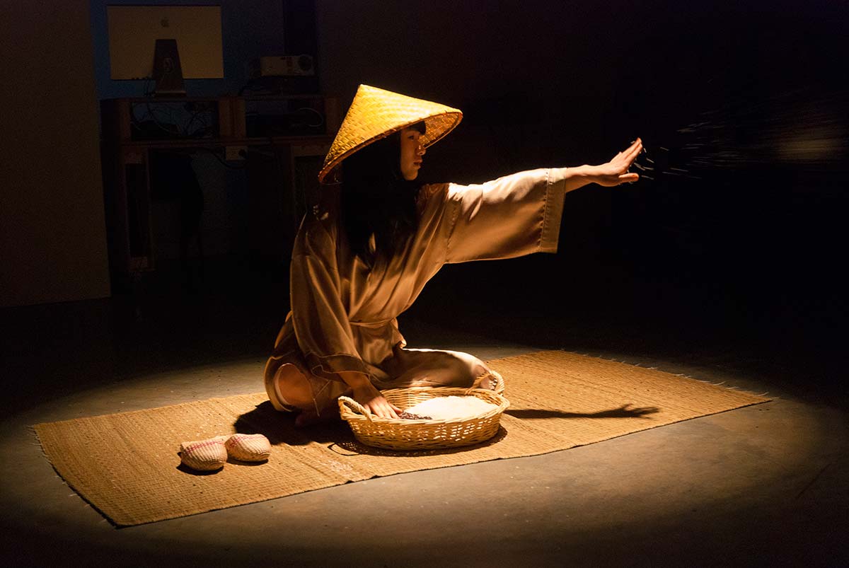Chun Hua Catherine Dong grabs a handful rice and throws it to audiences, the audiences can feel the gentle touch of the rice, the rice connects her and her audience