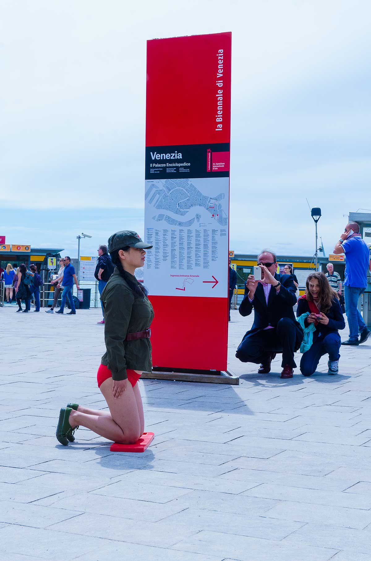 Chun Hua Catherine Dong wear a military suit and red underwear, kneeling on a washboard and keeping straight and still as long as she can in Venice Biennale in 2013