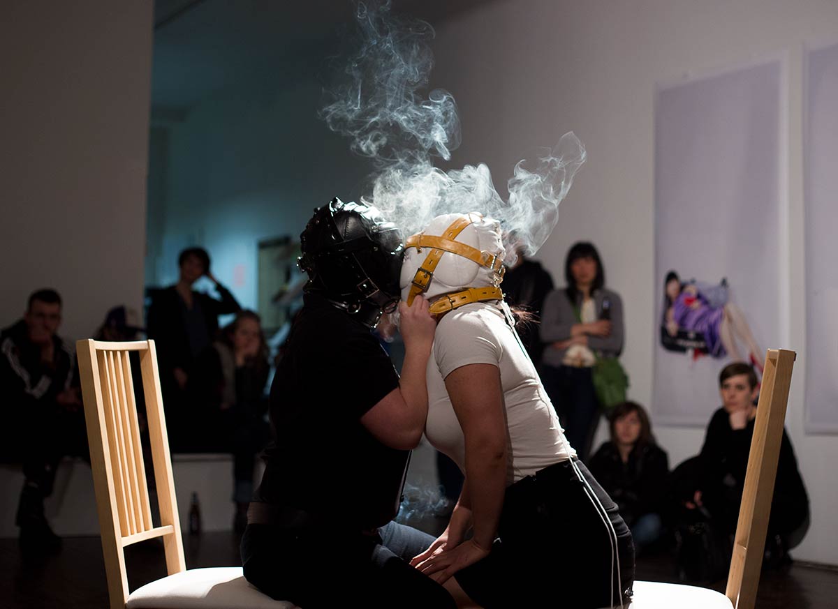 Chun Hua Catherine Dong performs at Articule Montreal: two females wear masks and kiss each other with smoke on their heads