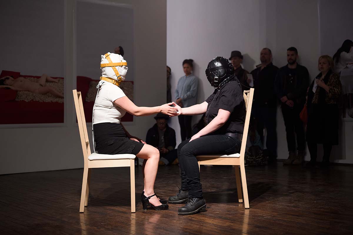 Chun Hua Catherine Dong performs at Articule Montreal: two females wear masks and touch each others 