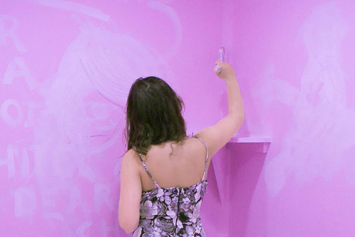 Chun Hua Catherine Dong paints Access Gallery to pink and invites viewers to paint the gallery back to white in Vancouver. This woman is painting the wall to white