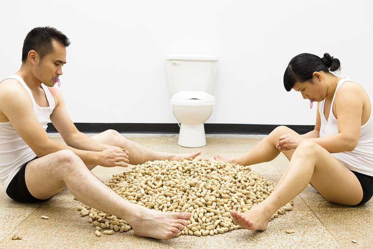 Chun Hua Catherine Dong and her performance partner are shucking peanuts, they throw peanut shells on floor and store peanut seeds in their underwear