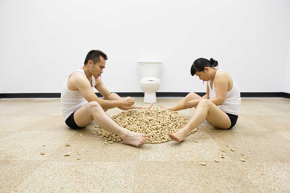 Chun Hua Catherine Dong and her performance partner are shucking peanuts, they throw peanut shells on floor and store peanut seeds in their underwear