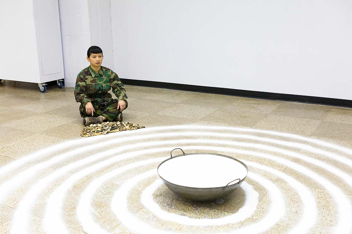 Chun Hua Catherine Dong is a soldier and she is meditating in front of salt and milk