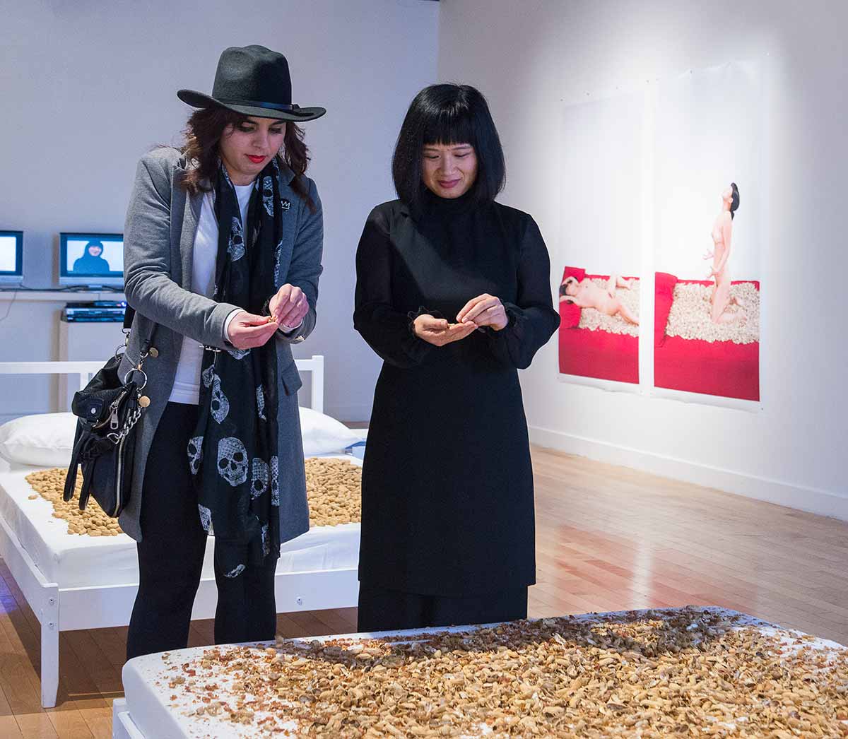 Chun Hua Catherine Dong shucks peanuts and leave peanuts’ shell on an empty bed, she also invites audiences to shuck peanuts with her