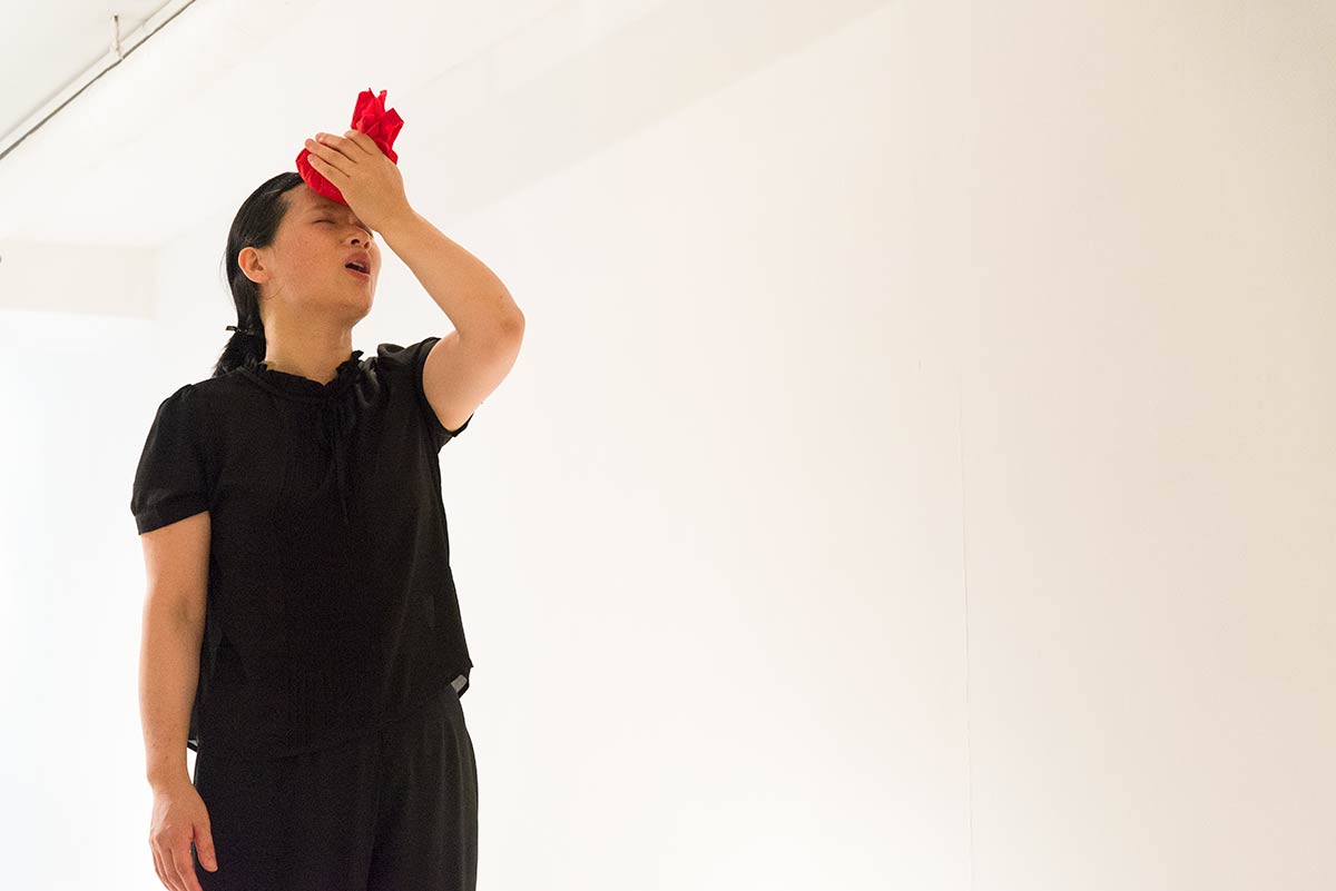 Chun Hua Catherine Dong's performance in New York: she wrapped rice with red handkerchiefs and form them to rice balls, she pressed a rice ball on her forehead and call her name to come home three times with her Chinese dialect