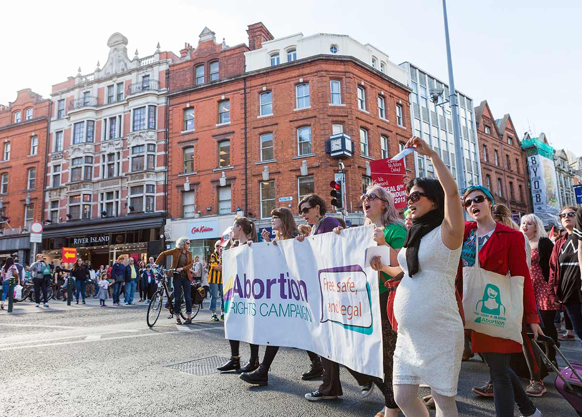 Chun Hua Catherine Dong is at Abortion Rights Campaign Ireland 2014, she held an picture of a woman in a dog cage, and matched with many women to support Abortion Right.