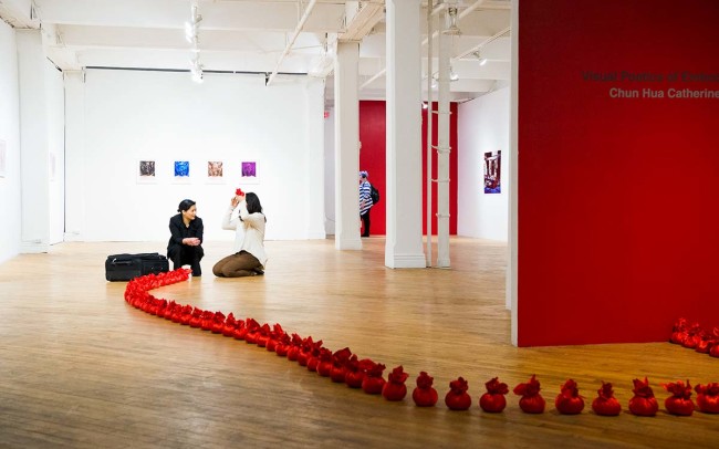 an audience is participating Chun Hua Catherine Dong's performance at her solo exhibition opening at aceartinc in Winnipeg 2016