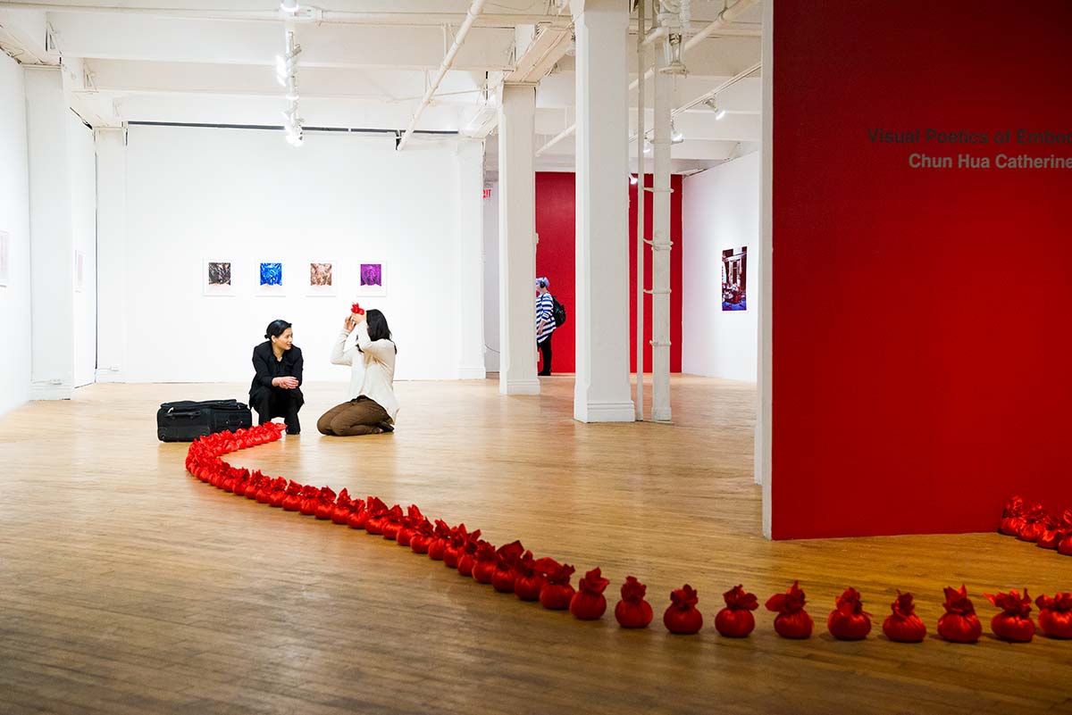 an audience is participating Chun Hua Catherine Dong's performance at her solo exhibition opening at aceartinc in Winnipeg 2016