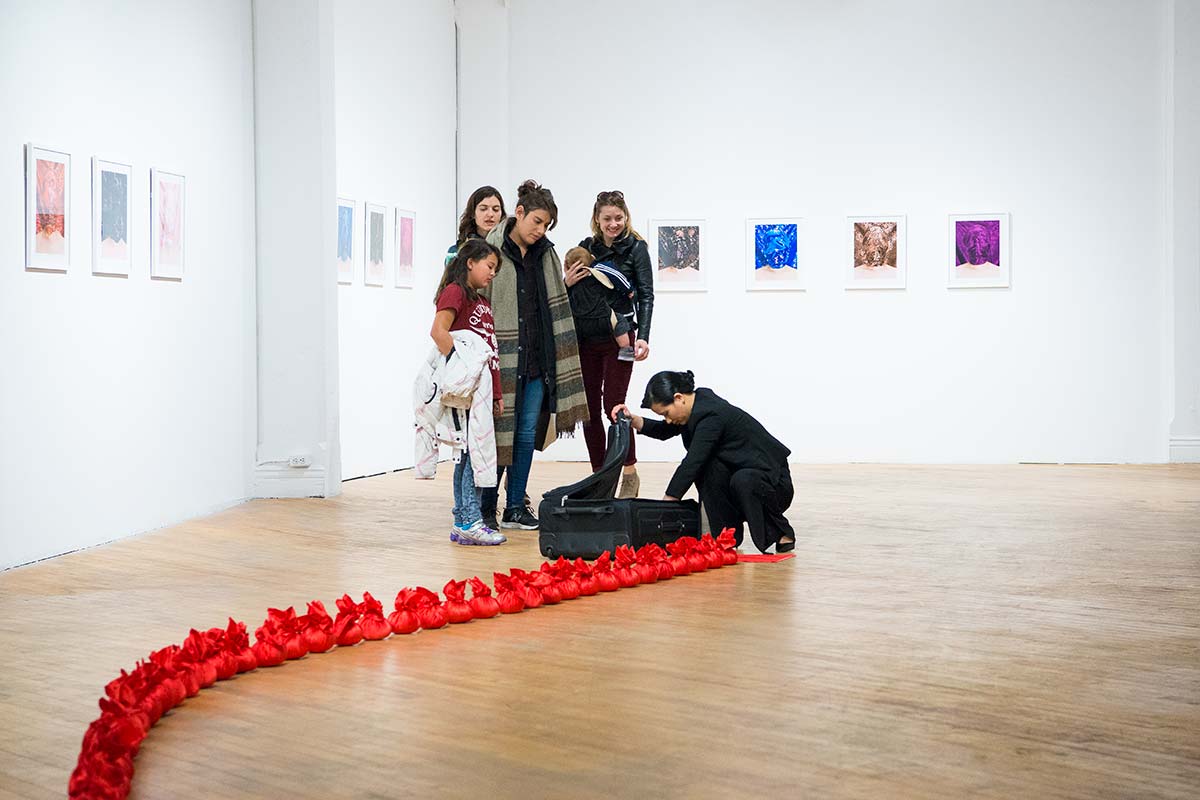 Chun Hua Catherine Dong makes rice balls at her solo exhibition opening at aceartinc in Winnipeg 2016 while audiences are watching