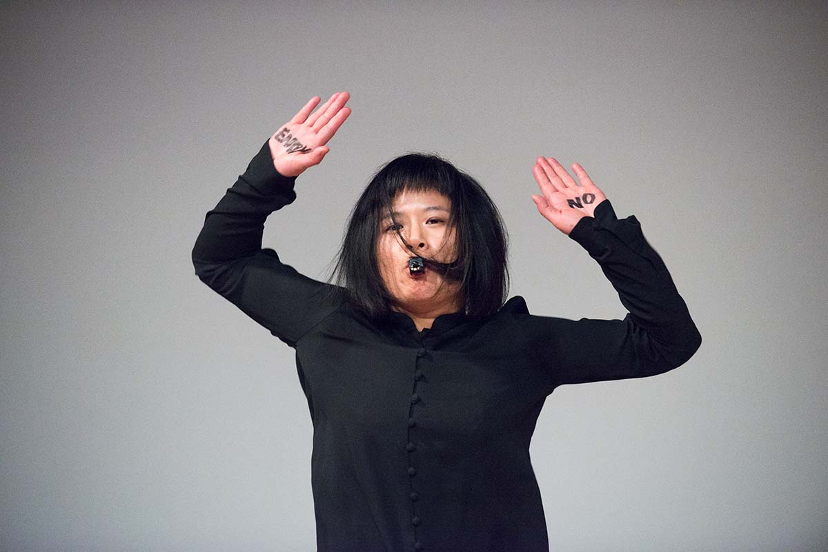 Chun Hua Catherine Dong's performance at 7a11d International Festival of Performance Art in 2016: Dong has words NO ENTRY on her hands