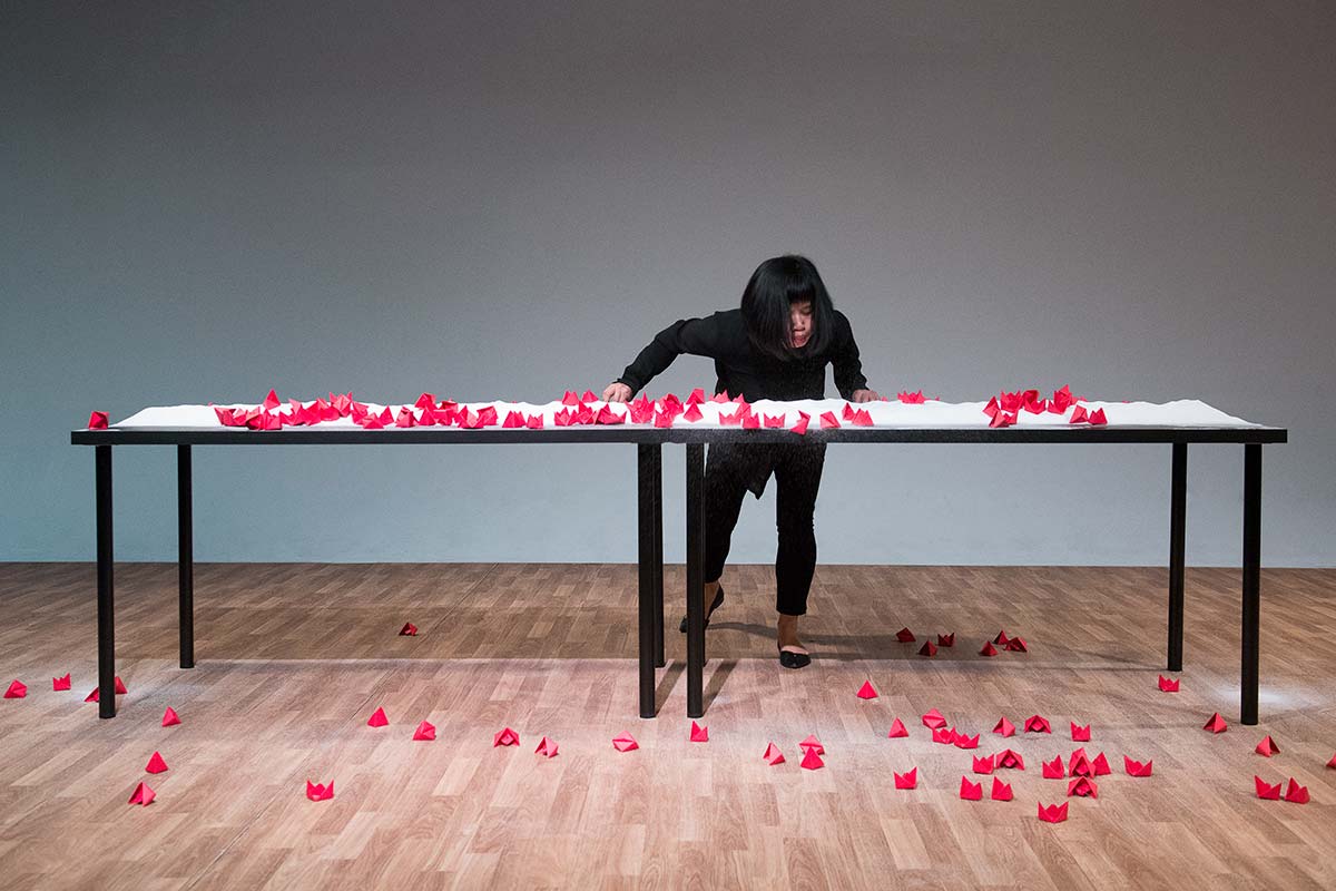 Chun Hua Catherine Dong's performance at 7a11d International Festival of Performance Art in 2016: Dong blows red paper boats to the floor