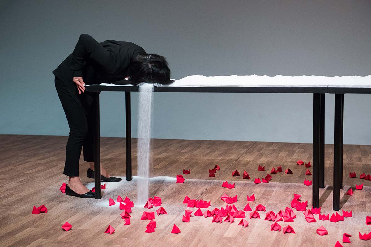 Chun Hua Catherine Dong's performance at 7a11d International Festival of Performance Art in 2016: Dong uses her hair to brush salt 