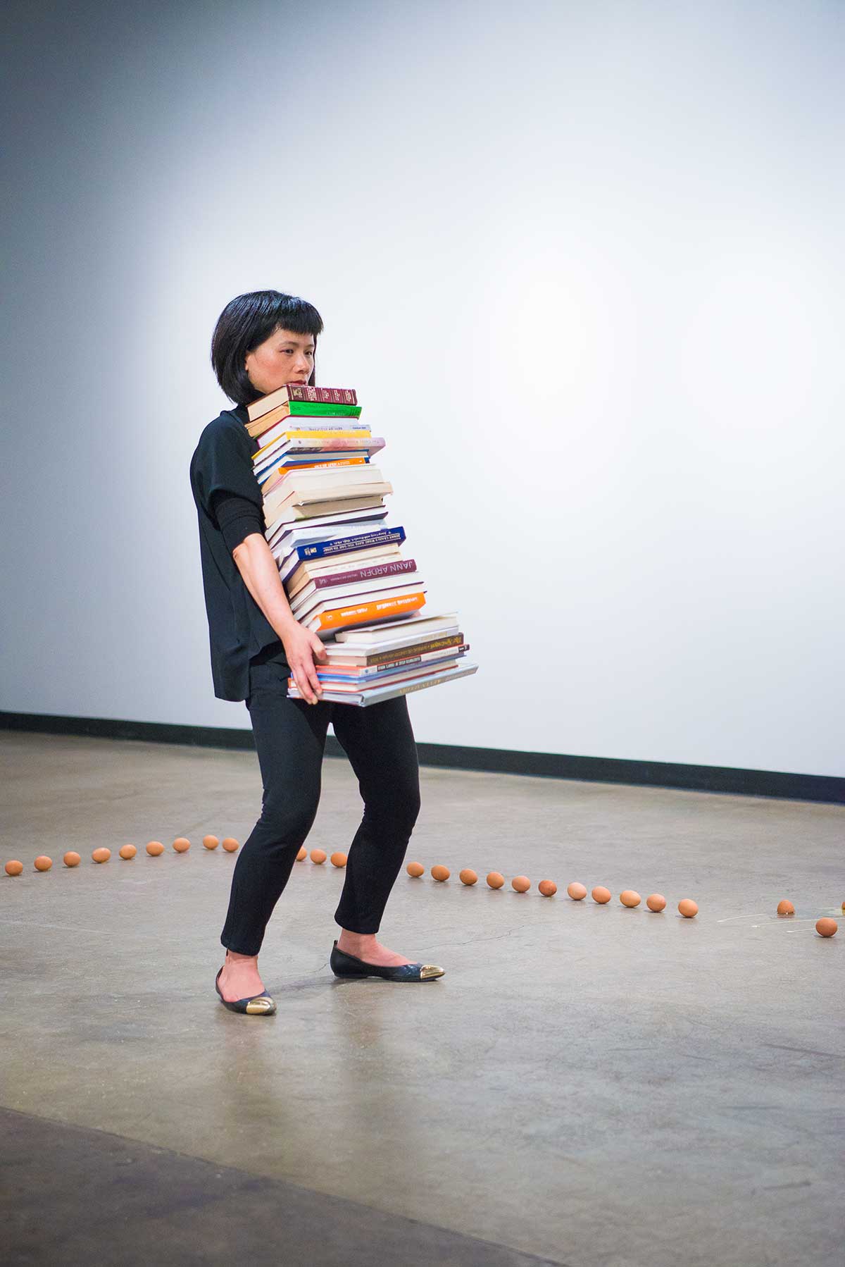 Chun Hua Catherine Dong holds a stack of books and keeps holding position as long as she can