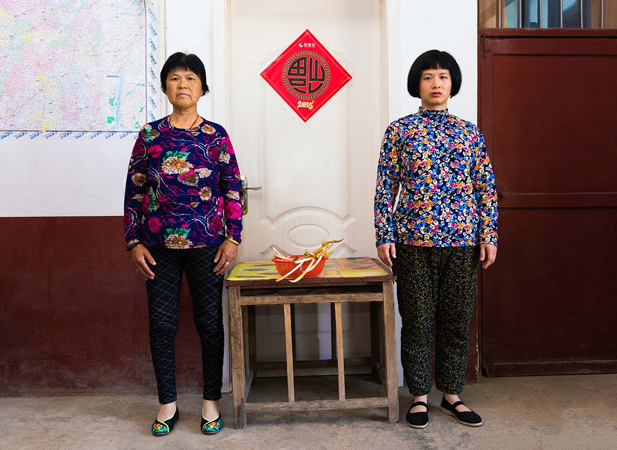 Chun Hua Catherine Dong and a mother sit beside a table, their postures mirror each other