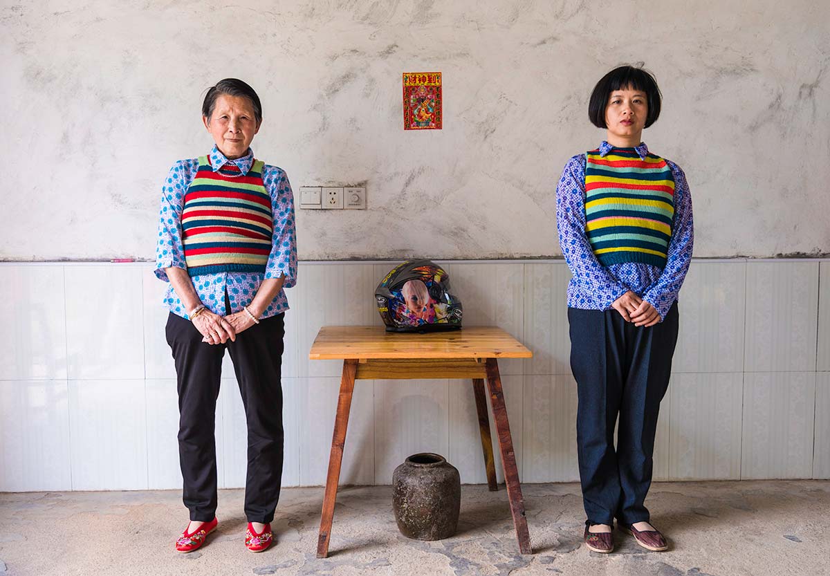 Chun Hua Catherine Dong and a mother sit beside a table, their postures mirror each other