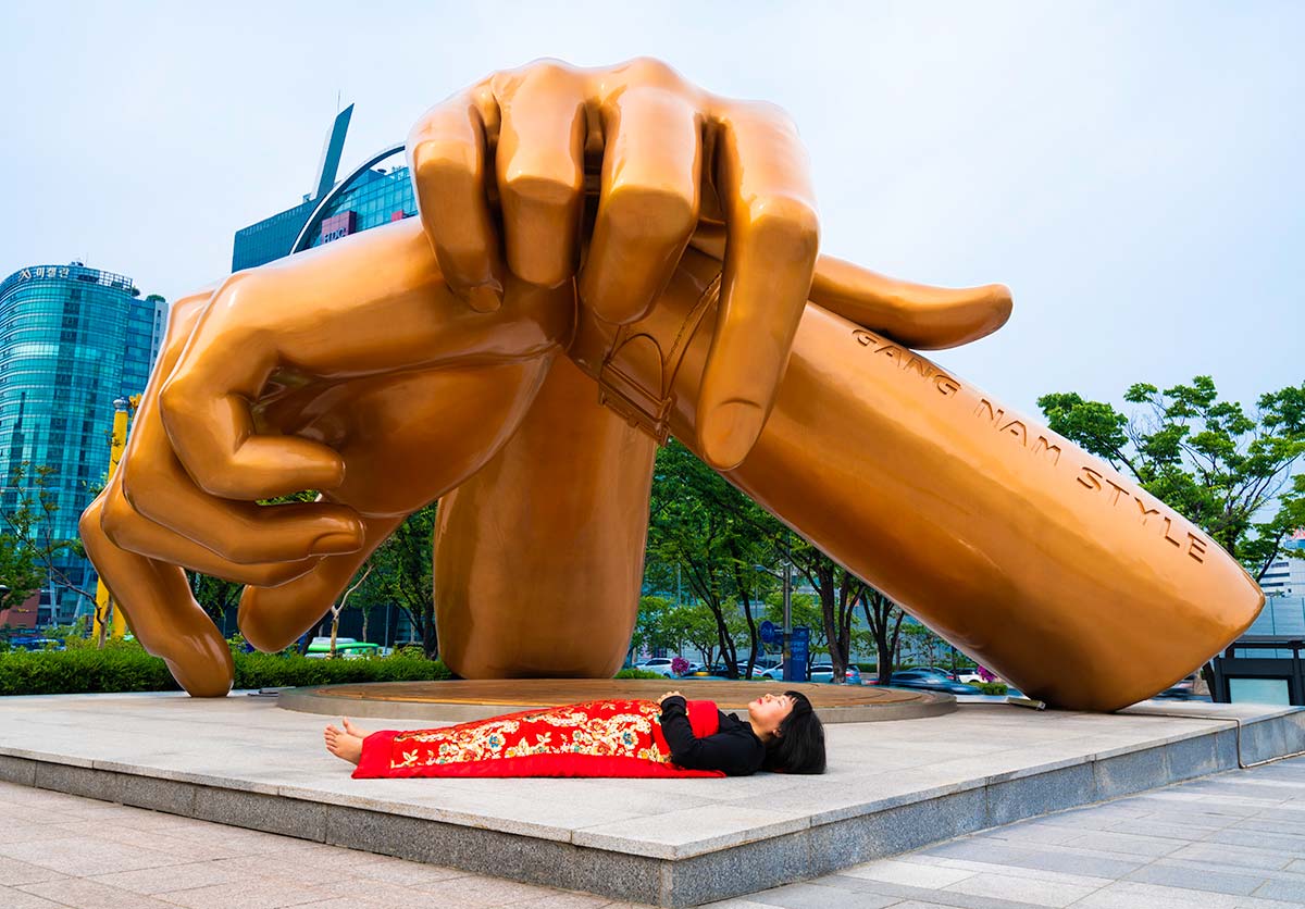 Chun Hua Catherine Dong buries herself with her red corpus cover at Gang Nam Style Status in Seoul