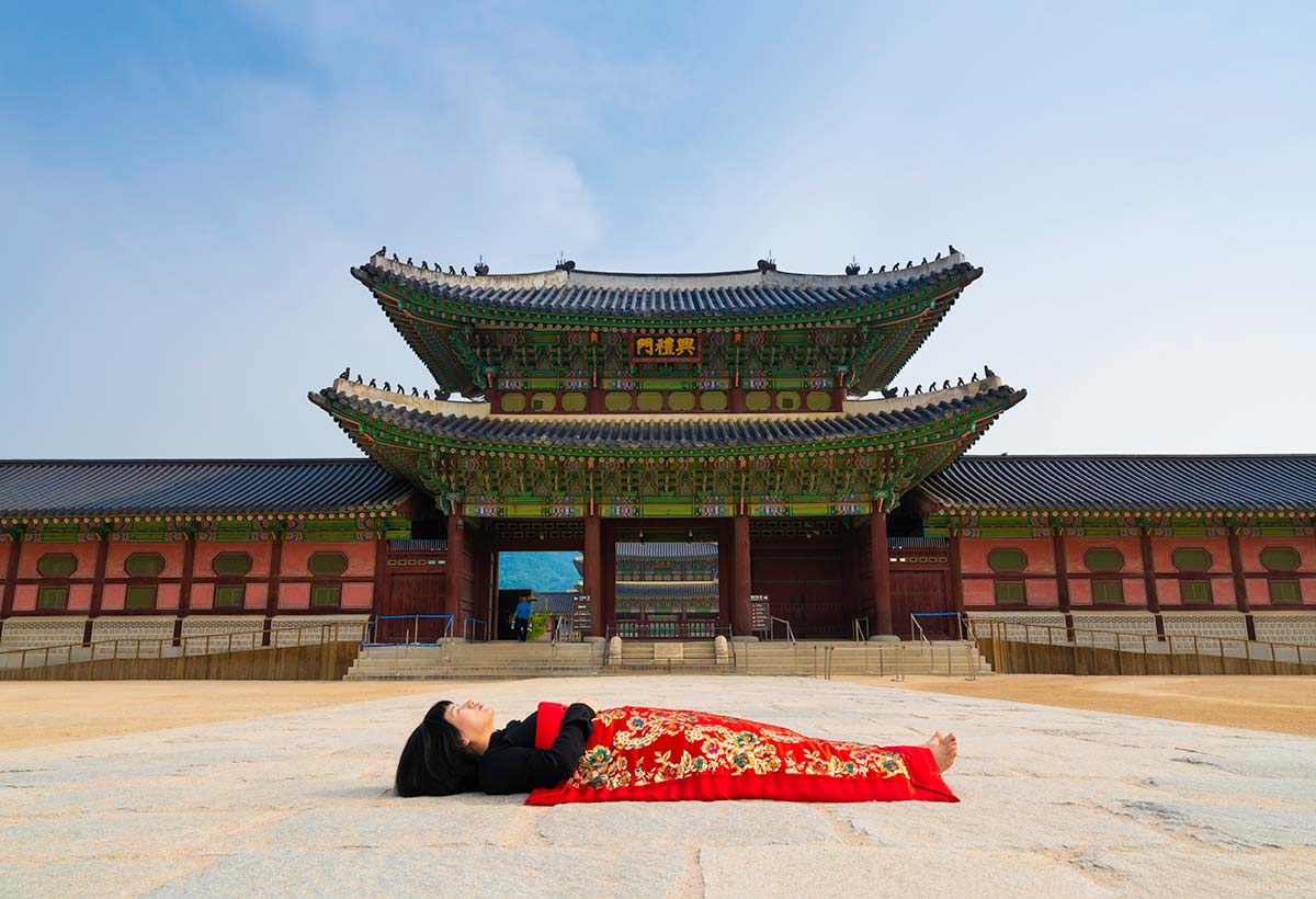 Chun Hua Catherine Dong buries herself with her red corpus cover at Gyeongbokgung Palace in Seoul