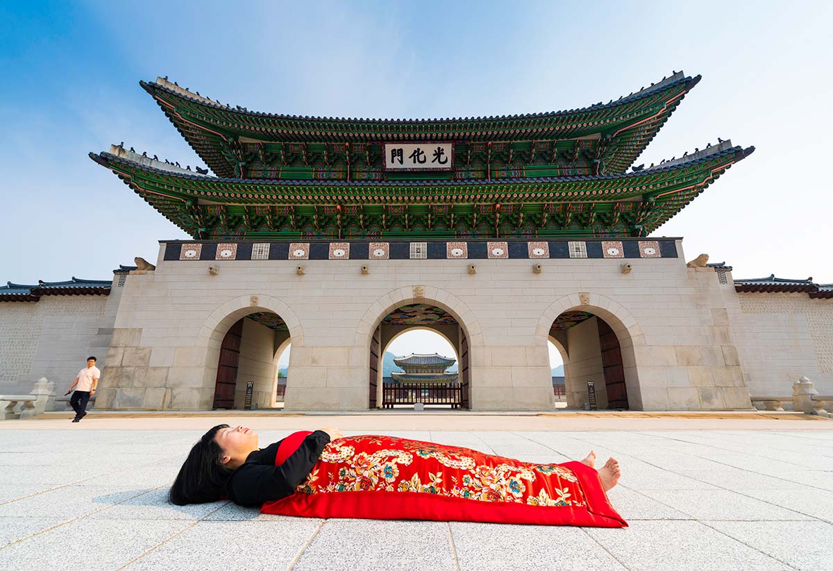 Chun Hua Catherine Dong buries herself with her red corpus cover at Gyeongbokgung Palace in Seoul