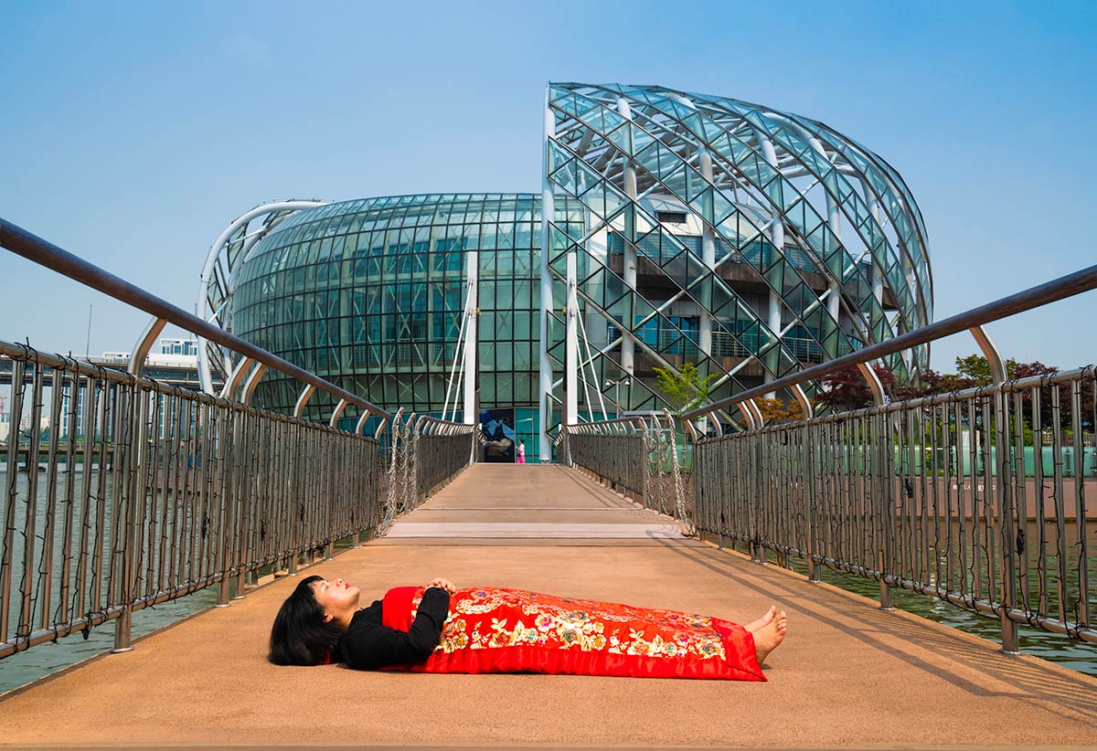 Chun Hua Catherine Dong buries herself with her red corpus cover at The Floating Islands in Seoul