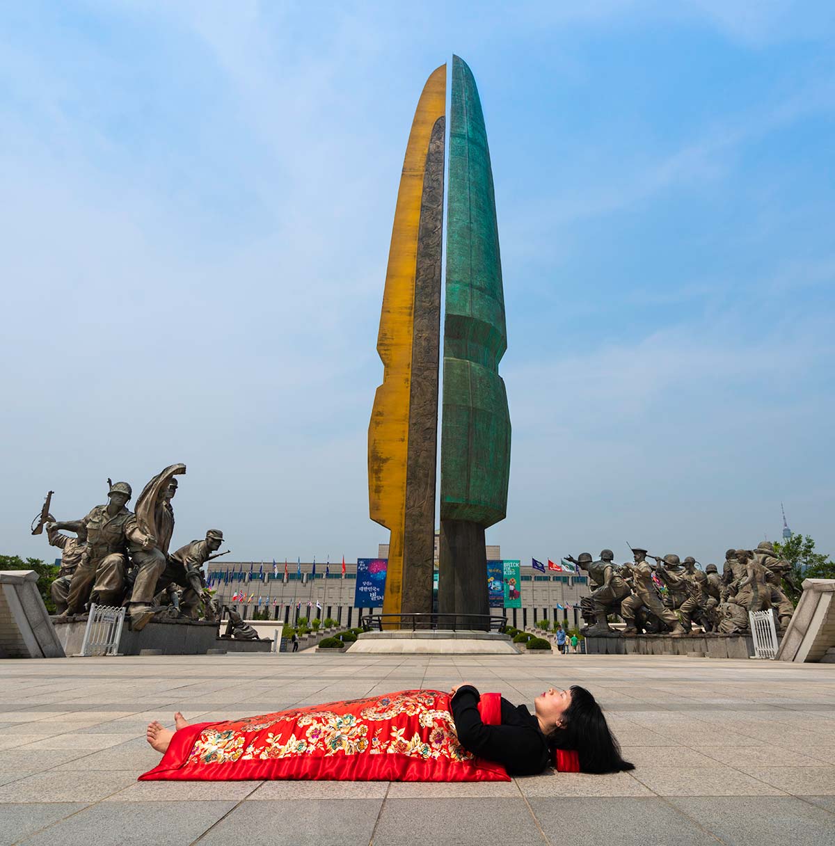 Chun Hua Catherine Dong buries herself with her red corpus cover at War Museum in Seoul