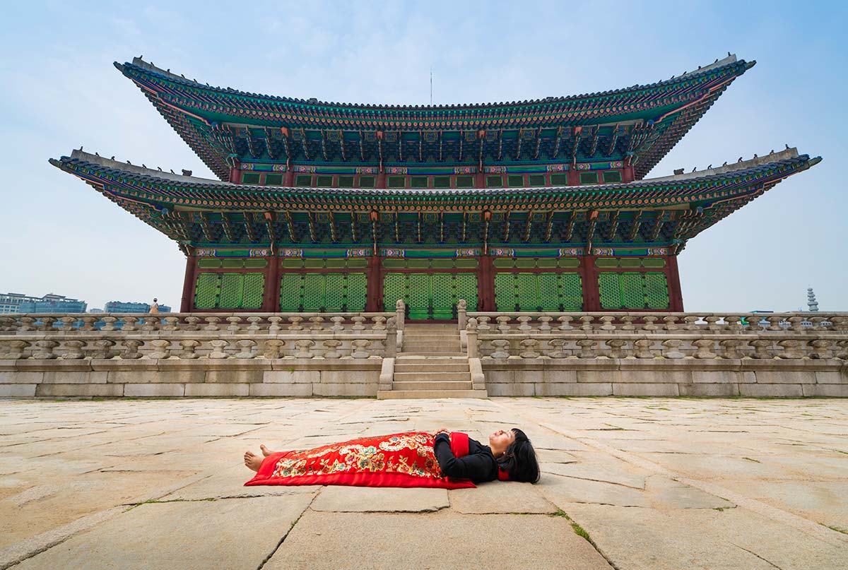 Chun Hua Catherine Dong buries herself with her red corpus cover at Gyeongbokgung Palace in Seoul