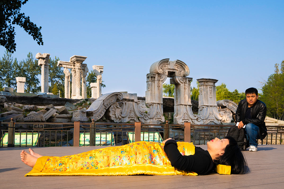 Chun Hua Catherine Dong covers herself with a duvet and performs death ritual at The Old Summer Palace in Beijing.