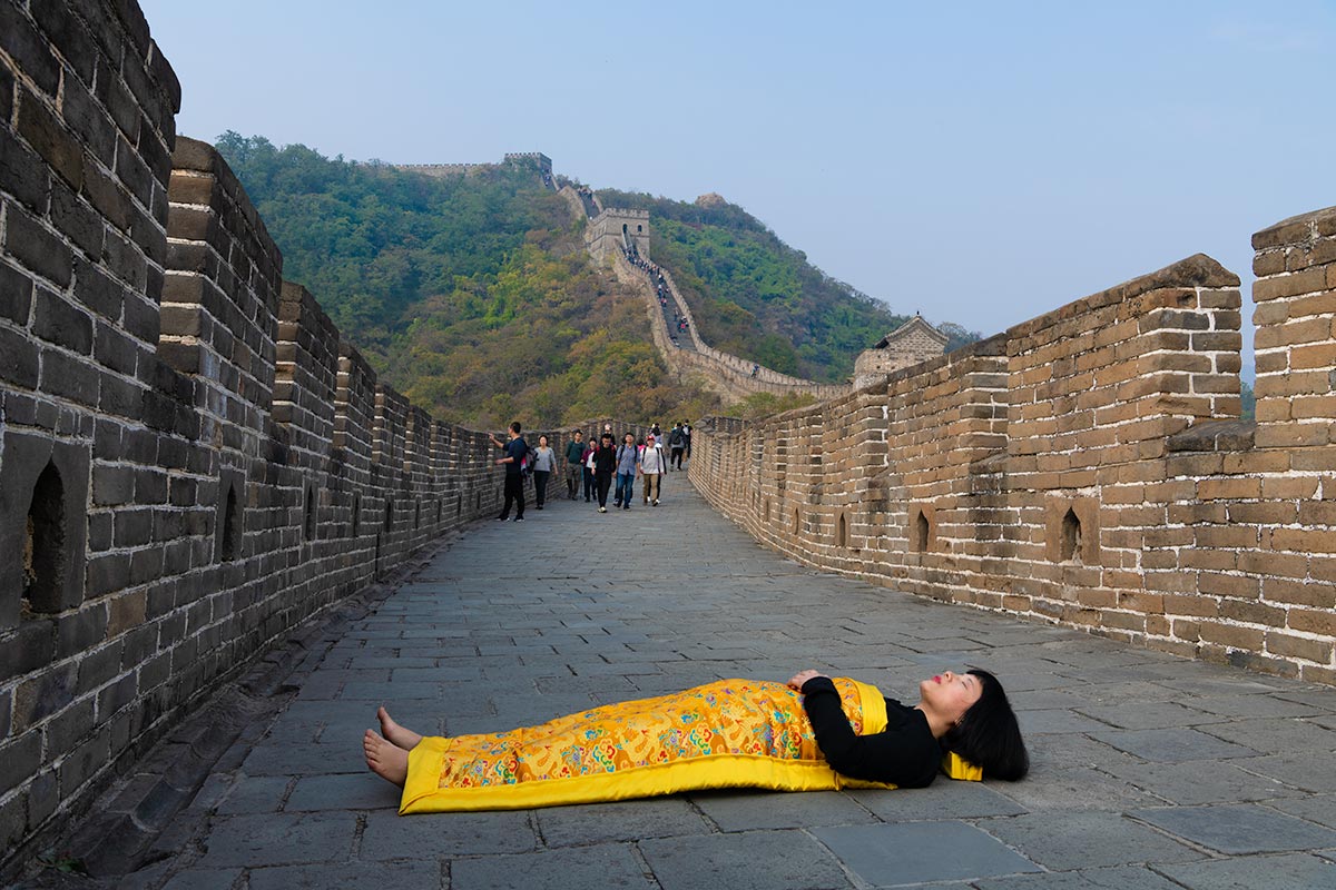 Chun Hua Catherine Dong covers herself with a duvet and performs death ritual at The Great Wall in Beijing.