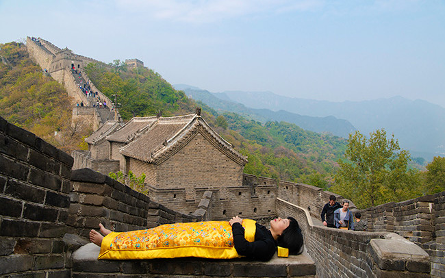 Chun Hua Catherine Dong covers herself with a duvet and performs death ritual at The Great Wall in Beijing.