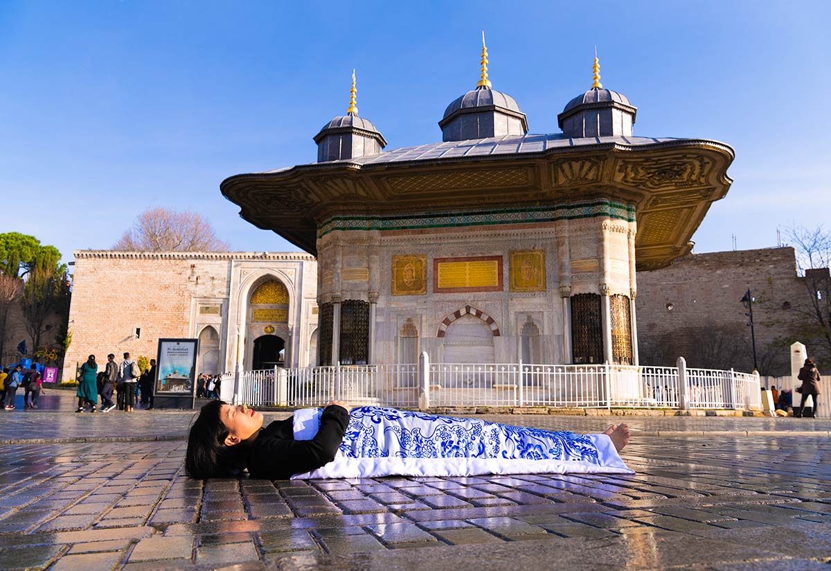 Chun Hua Catherine Dong covers herself with a duvet and performs death ritual  at 	Topkaipi Palace in Istanbul 