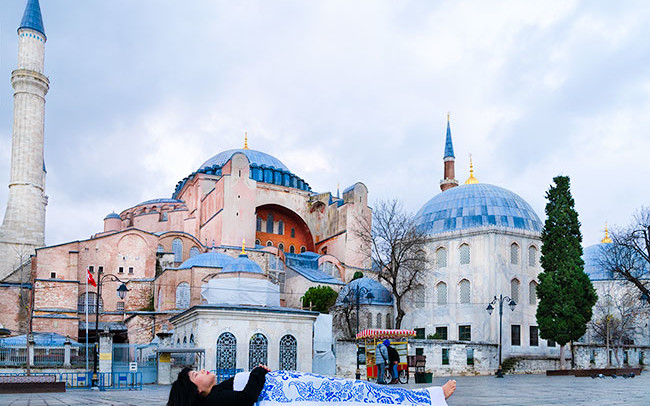 Chun Hua Catherine Dong covers herself with a duvet and performs death ritual in front of Hagia Sophia in Istanbul