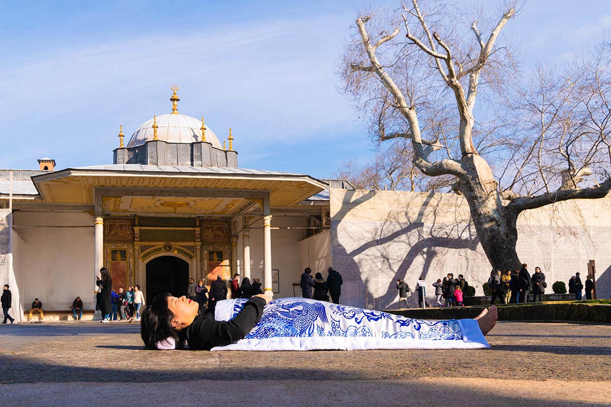 Chun Hua Catherine Dong covers herself with a duvet and performs death ritual  at 	Topkaipi Palace in Istanbul 