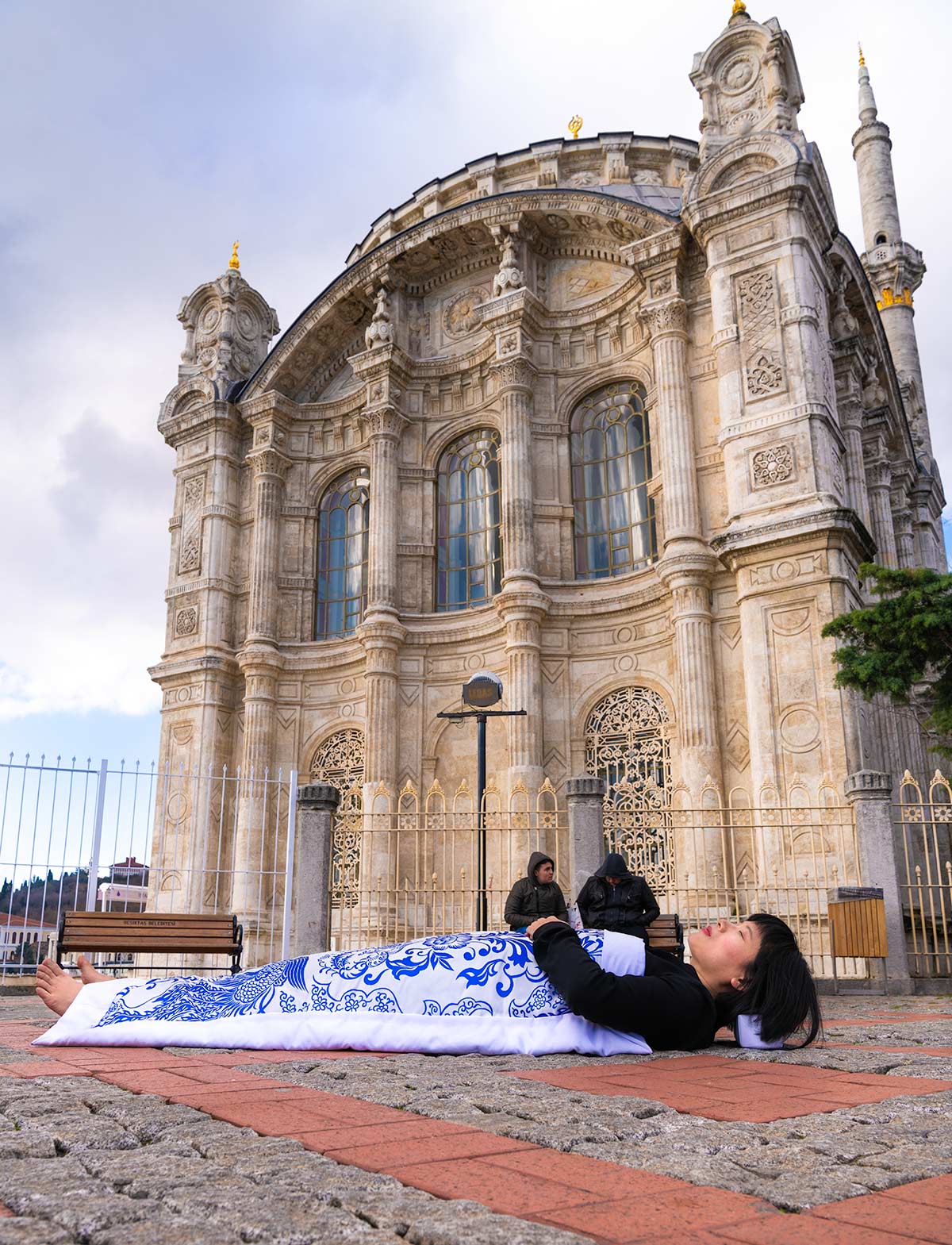 Chun Hua Catherine Dong covers herself with a duvet and performs death ritual  in front of a mosque in Istanbul