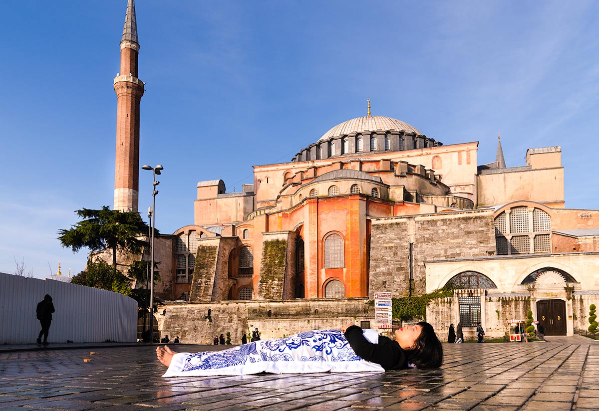 Chun Hua Catherine Dong covers herself with a duvet and performs death ritual in front of Hagia Sophia in Istanbul 