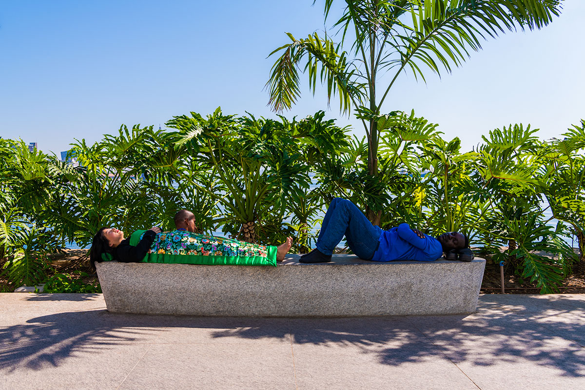 Chun Hua Catherine Dong sleeps with a man on a stone bench in rio de janeiro