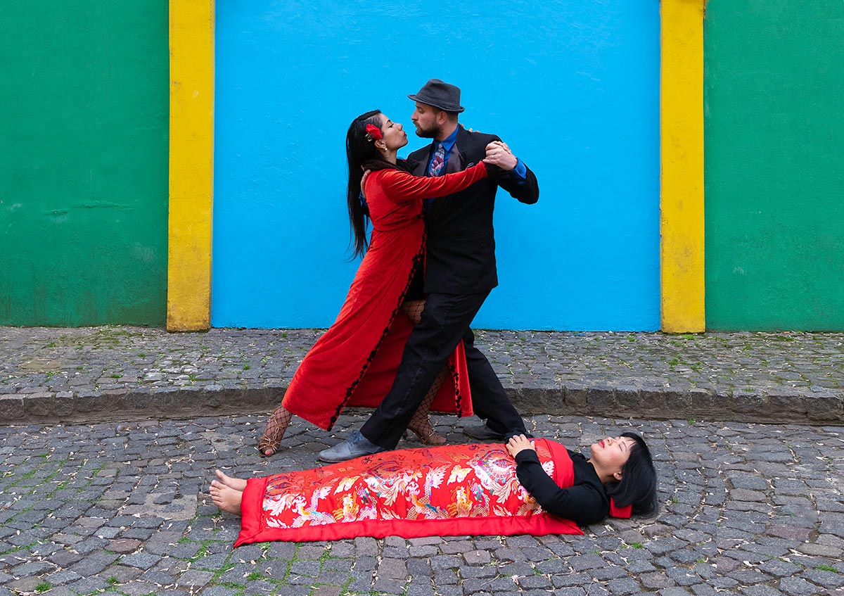 Chun Hua Catherine Dong sleeps in front of Tango dancers in Buenos Aires