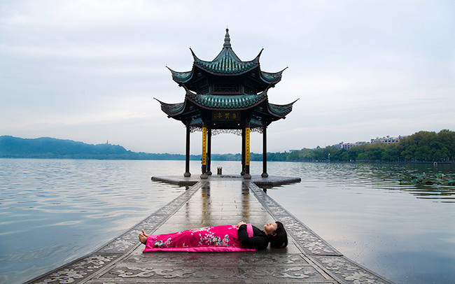 Chun Hua Catherine Dong sleeps in front of a big golden ball in HangZhou, China