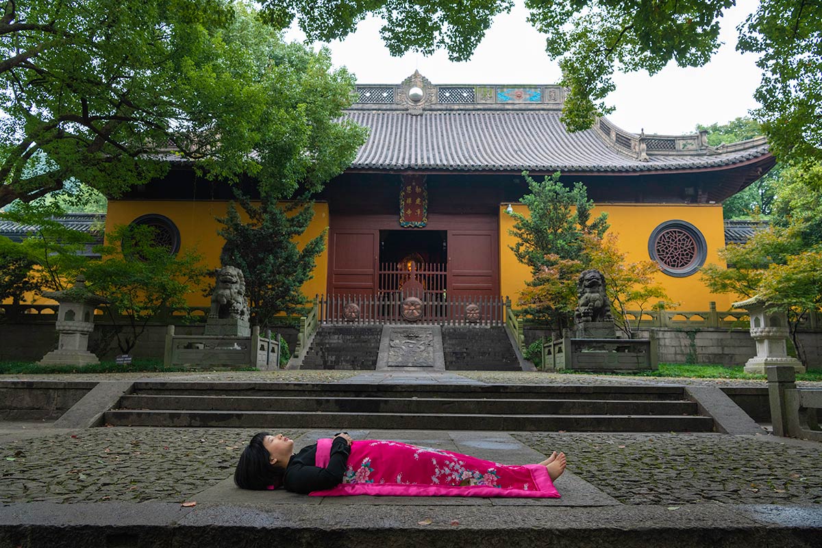 Chun Hua Catherine Dong sleeps in front of temple in HangZhou, China 