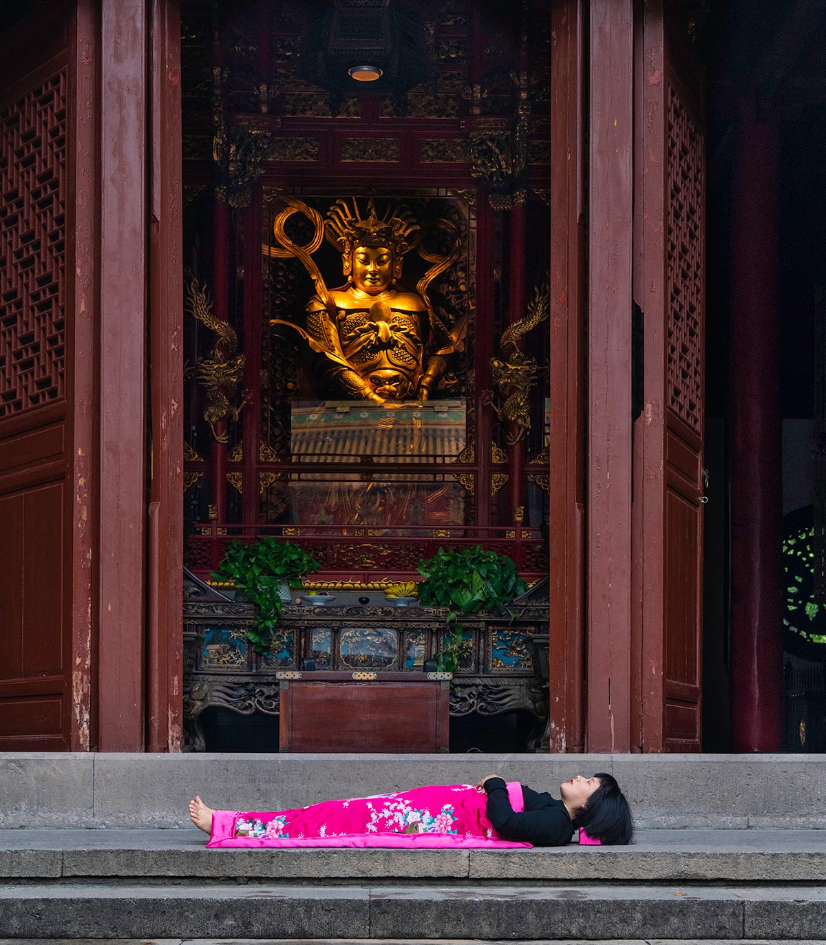 Chun Hua Catherine Dong sleeps in front of temple in HangZhou, China 