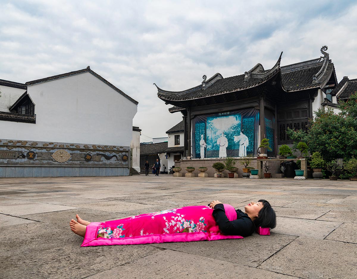 Chun Hua Catherine Dong sleeps in front of public stage for opera in HangZhou, China 