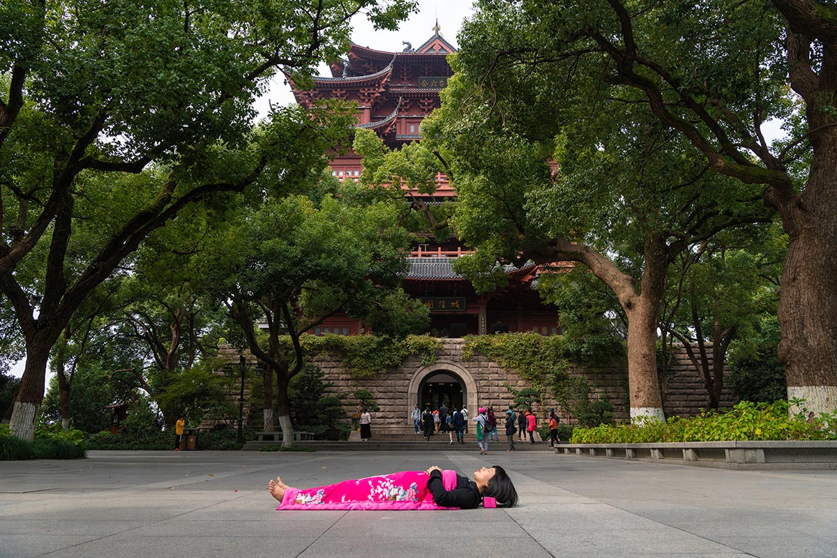 Chun Hua Catherine Dong sleeps in front of temple in HangZhou, China 