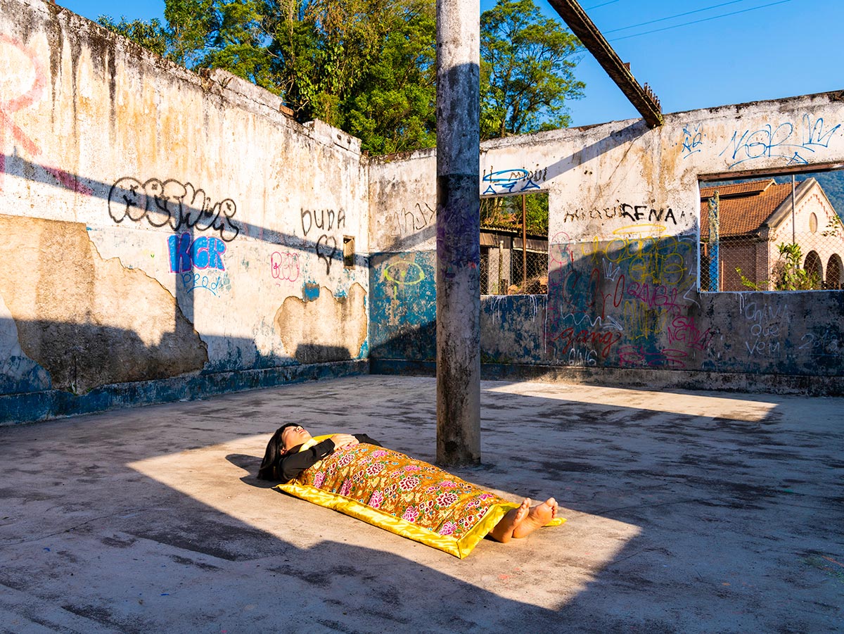 Chun Hua Catherine Dong sleeps in a box created by the sun in Sao Paulo