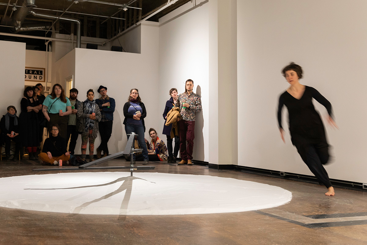 Chun Hua Catherine Dong’s dancer partner runs around salt clock at Neutral Ground Gallery