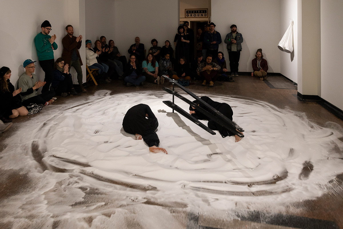 Chun Hua Catherine Dong and her dancer partner sleep on salt clock and look at each other at Neutral Ground Gallery