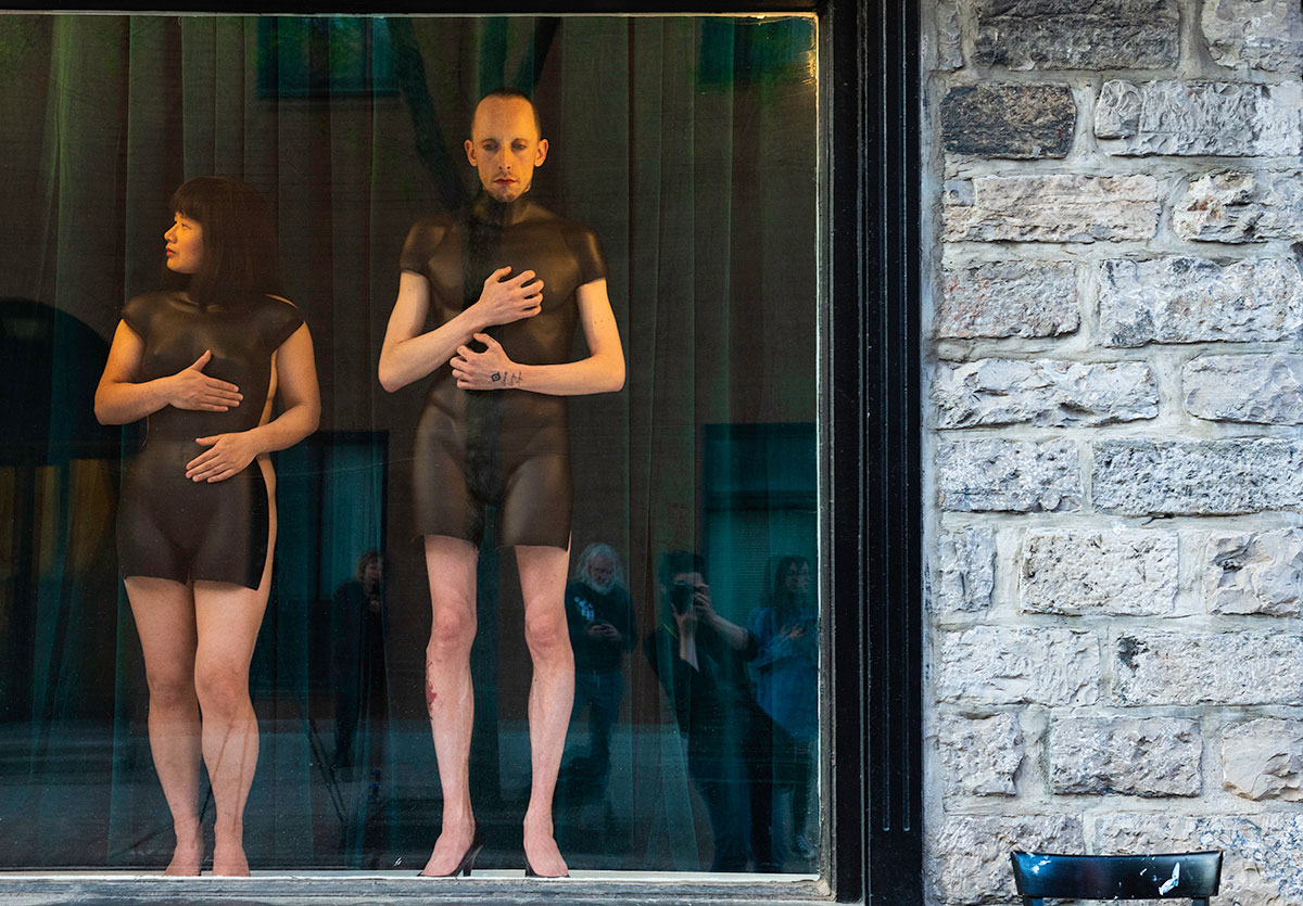 Chun Hua Catherine Dong and her performance partner wear mannequin torsos and perform on a window at Le Lieu, centre en art actuel, Quebec City 