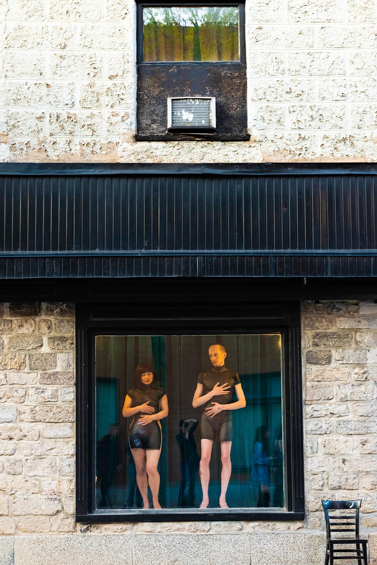 Chun Hua Catherine Dong and her performance partner wear mannequin torsos and perform on a window at Le Lieu, centre en art actuel, Quebec City 