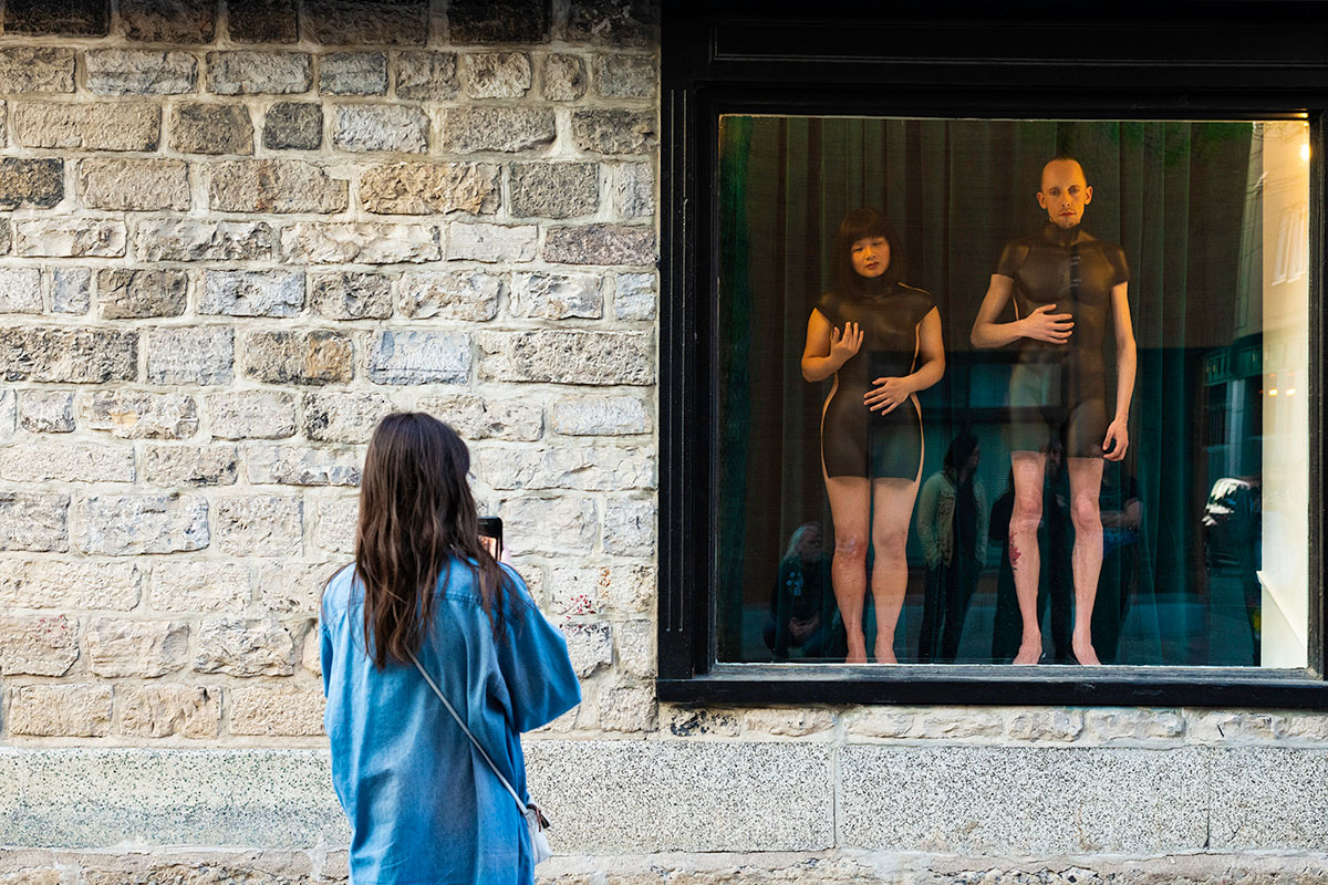 Chun Hua Catherine Dong and her performance partner wear mannequin torsos and perform on a window at Le Lieu, centre en art actuel, Quebec City 