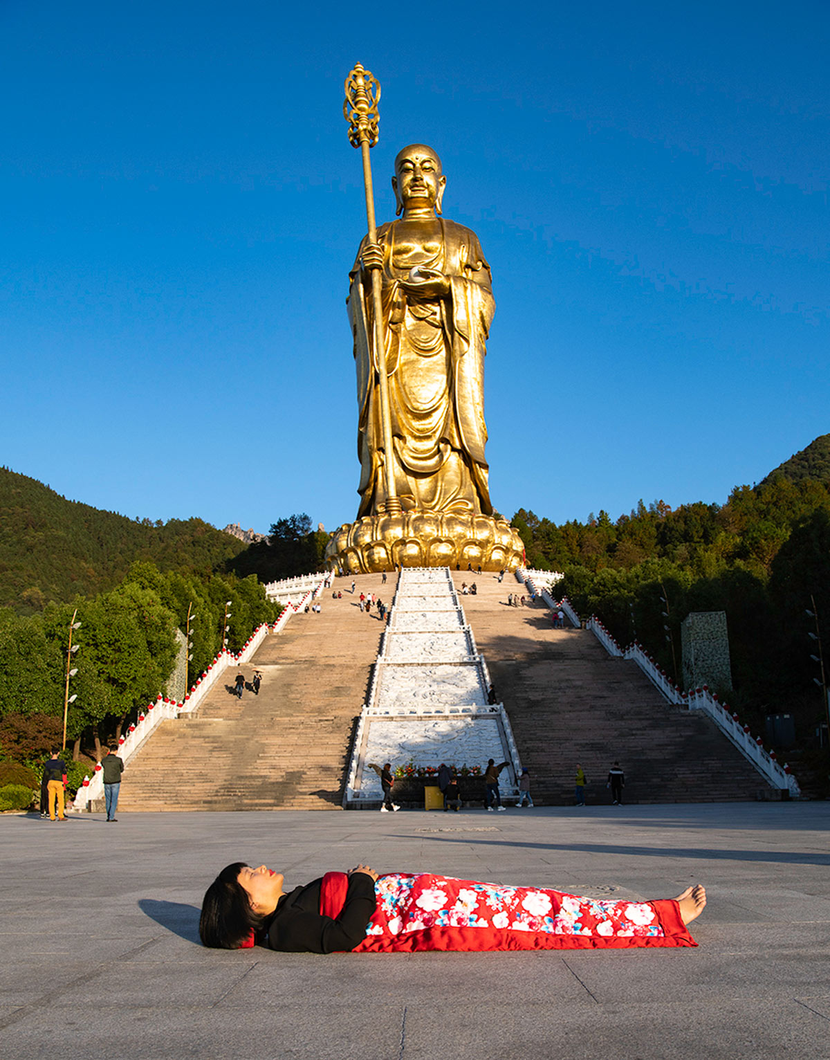 Chun Hua Catherine Dong celebrates her death and sleeps in front of a big gold Buddha in Mountain JiuHua, China