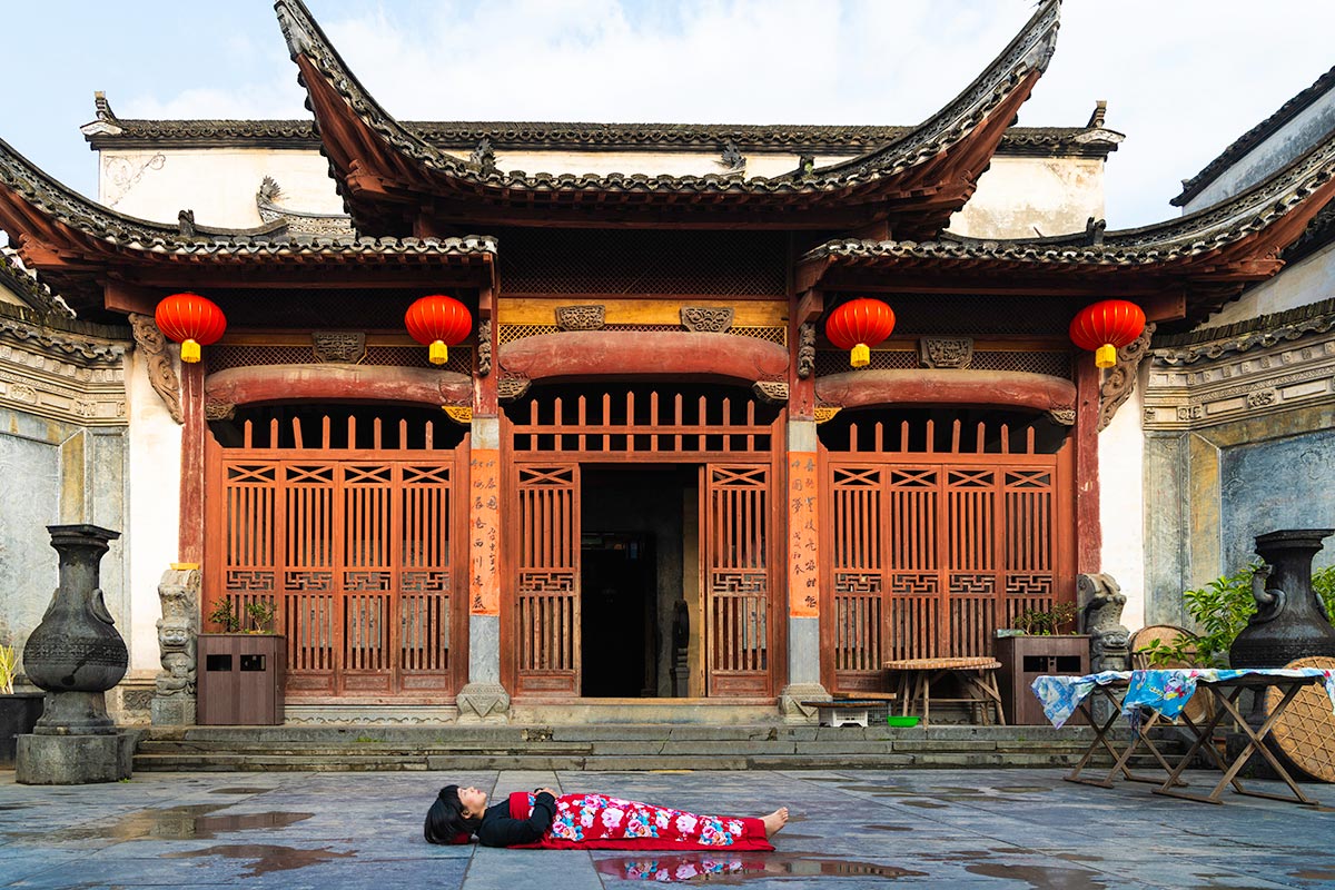 Chun Hua Catherine Dong celebrates her death and sleeps in front of orange temples in Mountain JiuHua, China