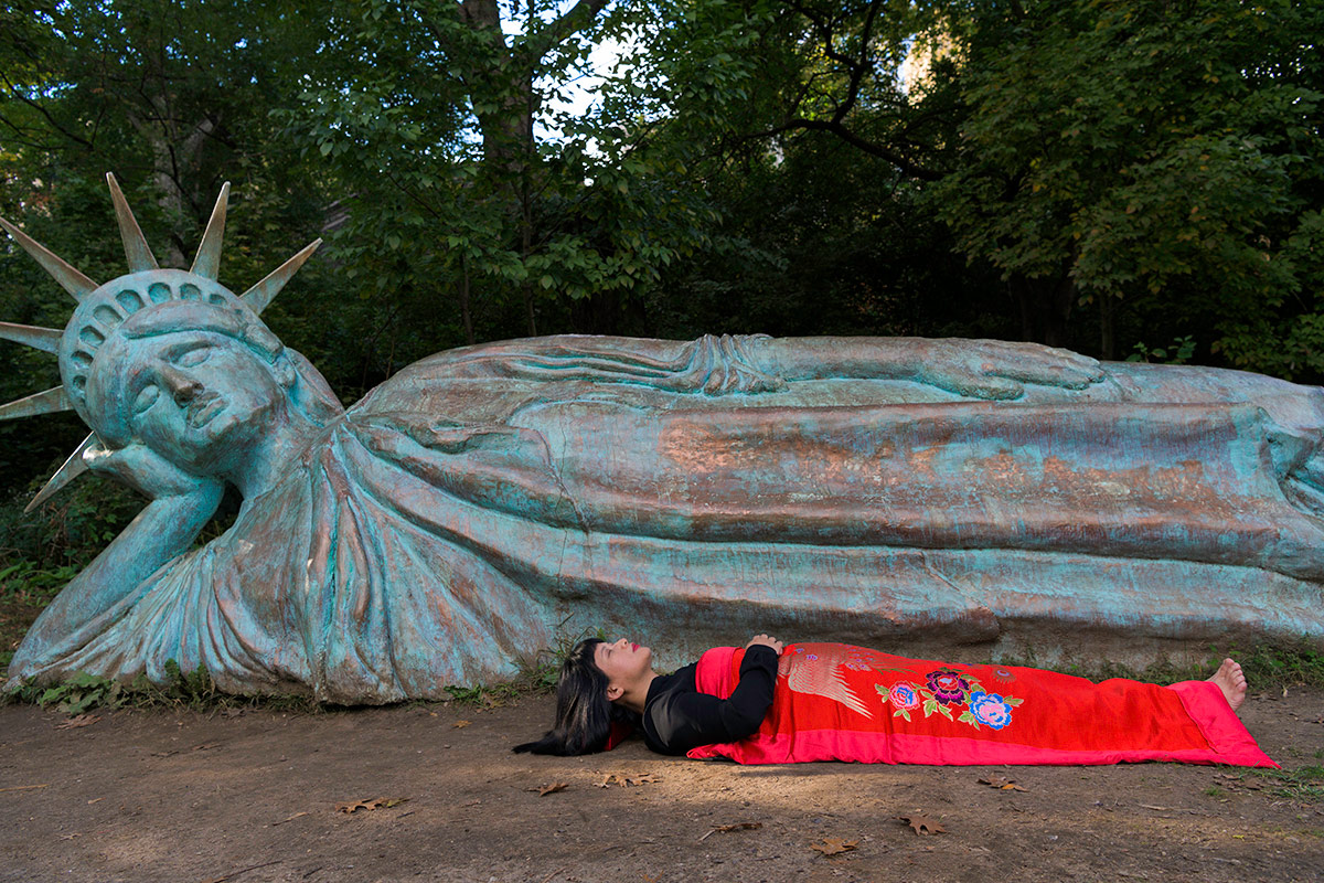 Chun Hua Catherine Dong sleep in front of Statue of Liberty in New York City